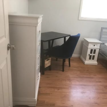 Furnished Boise State student room with hardwood floors, dresser, and study desk at Malad House off-campus rentals.