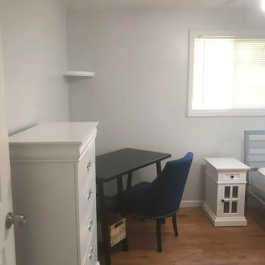 Furnished Boise State student room with hardwood floors, dresser, and study desk at Malad House off-campus rentals.