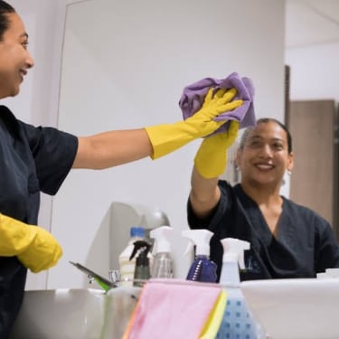 Maria cleaning restroom mirror