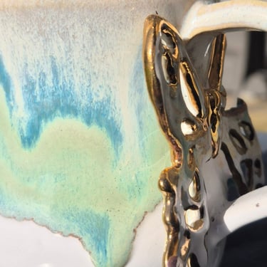 Ceramic mug with bright gold lustre after hand-washing, maintaining high-shine reflective finish.