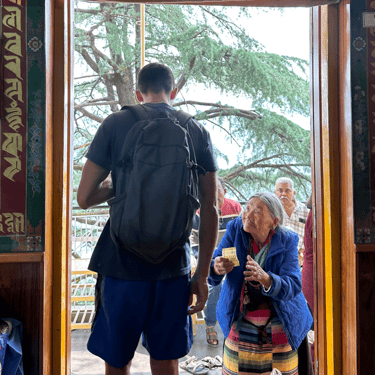 An elderly lady asking for help from a young man. 