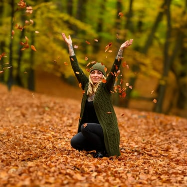 Frau wirft Herbstblätter in die Luft und lacht, aufgenommen von Lens & Look im Wald bei Oranienburg | Cinematische Portraitfo