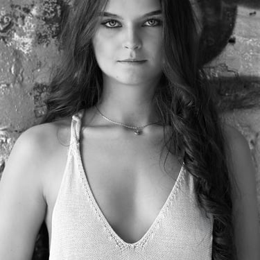 Schwarz-Weiß-Porträt einer jungen Frau vor einer strukturierten Wand in Oranienburg.