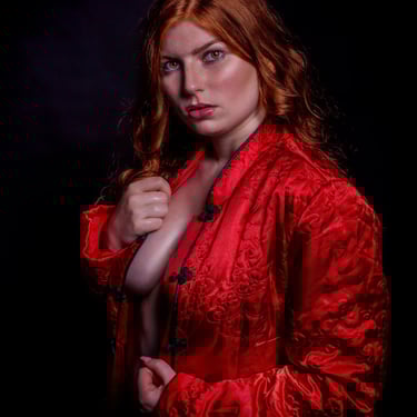 Fashion-Portrait einer Frau mit roten Haaren und roter Jacke im Studio