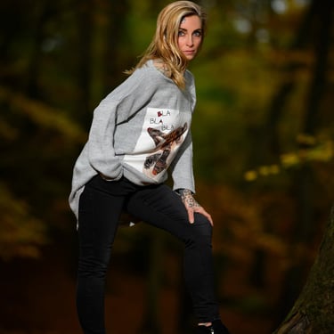 Porträt einer Frau im grauen Pullover mit Tattoos, aufgenommen im herbstlichen Wald von Lens & Look | Cinematische Portraitfo