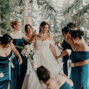 Bride surrounded by bridesmaids in teal dresses helping with her gown before the wedding – captured by Anngye & Juan Photogra