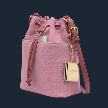 Tas kantong serut berwarna rose pink dengan tali cokelat dan pesona buku emas