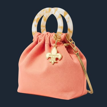 Tas kantong berwarna peach dengan gagang resin efek marmer di latar belakang putih.