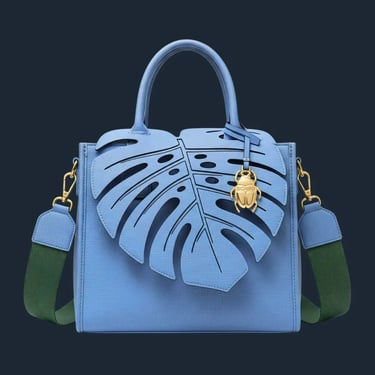 Tas jinjing biru telur asin dengan tutup berbentuk daun Monstera dan tali hijau di latar belakang putih.