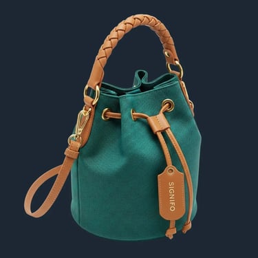 Tas bucket dari kain kanvas hijau sage SIGNIFO dengan handle kulit anyam dan tali selempang.