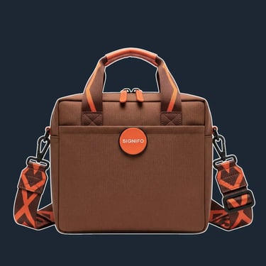 A modern, boxy 'camera bag' style tote with a zip-around top closure and a very clean, geometric form