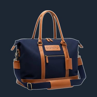 Weekender tote kanvas dongker dengan aksen kulit sintetis cokelat dan saku depan.