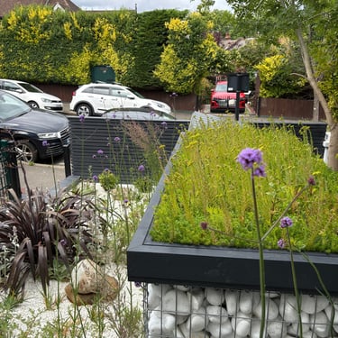 Green roog pebble bin store in mediterranean style front garden