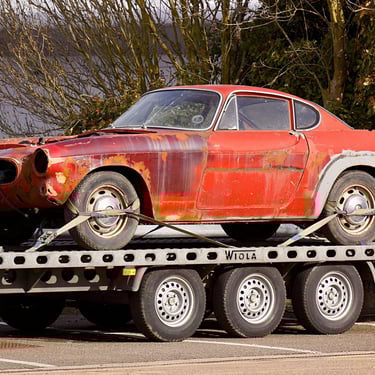 a car is being towed down a flatbed trailer