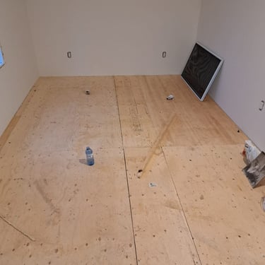 Completed levelled plywood subfloor installation in a renovated room, ready for final flooring finish