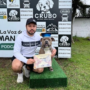 A man posing with a pitbull wearing a graduation cap and holding a training diploma at Crubo dog academy.