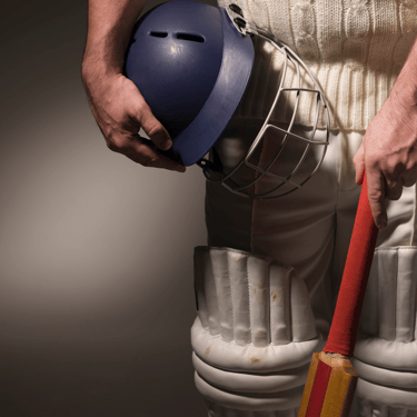 a man wearing white cricket uniform holding cricket bat and helmet and wearing pads