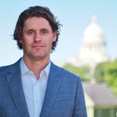 Arkansas Criminal Defense Lawyer Kale Ludwig poses in front of State Capital Building