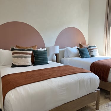 Two custom-painted headboard accents featuring unique designs, adding a personalized and artistic touch to a modern bedroom.
