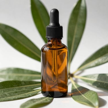 Sleek amber glass bottle next to green botanical leaves, high-contrast morning sun