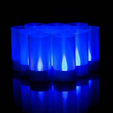 Set of frost‑blue LED ritual candles glowing with cold light, styled for horror décor and occult