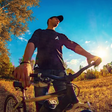 homme à vélo en forêt portant un vêtement technique  Ascentierra