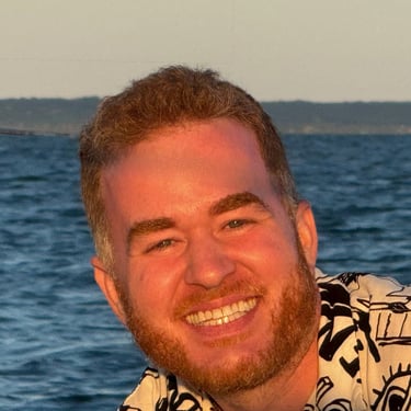 a happy custom sailboat charter customer smiling man with a beard and a shirt on