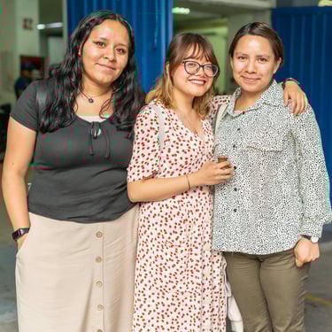 three women standing next to each other in a warehouse
