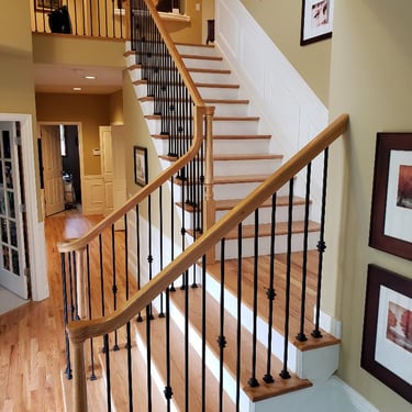 Vision Flooring and More installed solid oak treads over stairs as well as new iron balusters.
