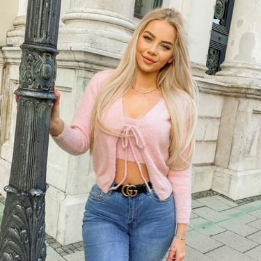 femme en pull rose et jean