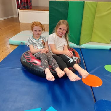 two girls practicing pointy toes in SEND gymnastics session