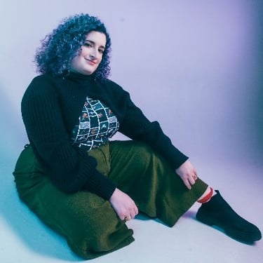 a woman with blue hair and a black sweater