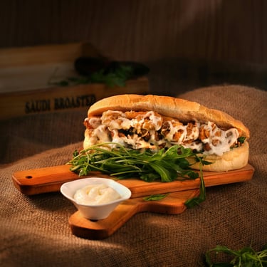 Sándwich en una tabla de cortar con mayonesa en un plato blanco delante