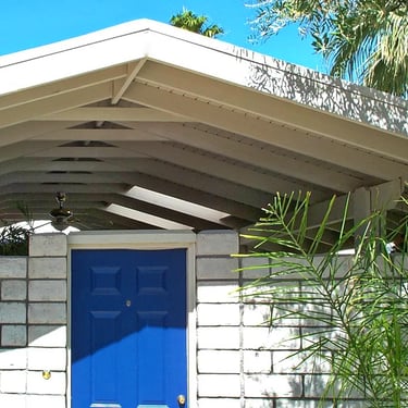 Gabled wood roof structure over courtyard entry area.
