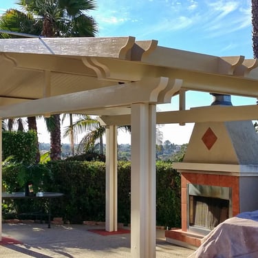 Freestanding Alumawood gazebo with peaked roof and fireplace.