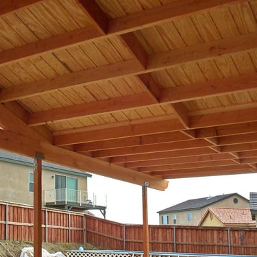 Small wood patio cover with gabled roof and corbel rafter tails.