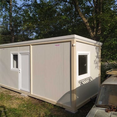 kontejner za stanovanje u dvoristu pored old tajmer automobila