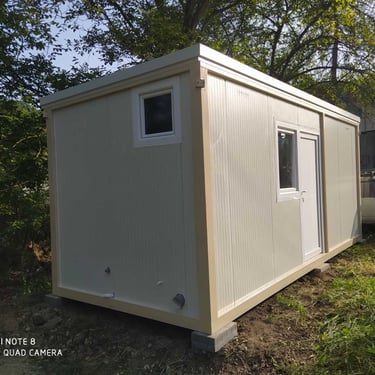 kontejner sa kosim krovom mali prozor vrata i veliki prozor bele boje