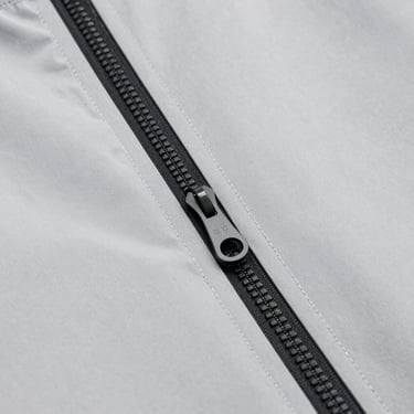 Detail of a technical waterproof jacket zipper and clean seams, minimalist industrial style, sharp focus