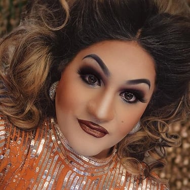 drag queen dixie surewood with gold dress and glam makeup