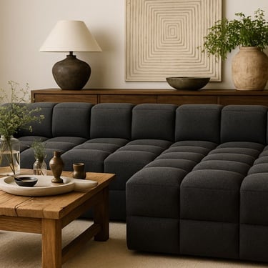 Oversized dark gray cube sectional in a warm modern living room with rustic wood coffee table, sideboard, and earthy decor by