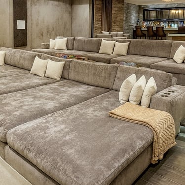 Plush tiered sectional seating with gray upholstery, and cup holders, designed for a luxury home theater by Solo Home Decor