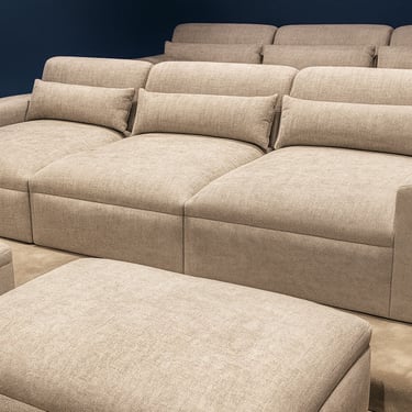 Solo Home Decor theater ottoman and plush sectional seating in soft neutral fabric for a refined luxury cinema style.