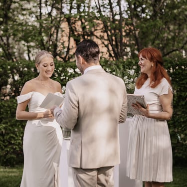 Braut und Bräutigam lesen sich während der freien Trauung ihre Eheversprechen vor.