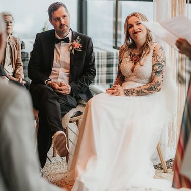 das stark tätowierte Hochzeitspaar lauscht ihrer Liebesgeschichte. die Braut schmunzelt.