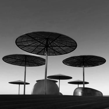 Black and white photo of umbrellas on a pier