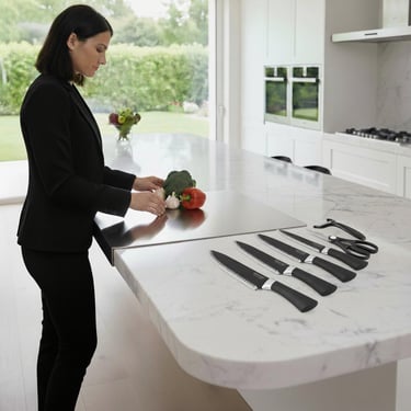 Premium chef knife, paring knife, peeler, ready to be used by chef on steel cutting board in kitchen