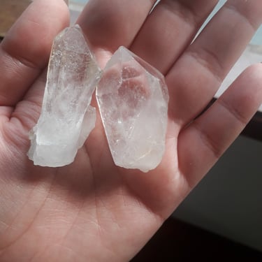 uma pessoa segurando dois pedaços de pedras transparentes