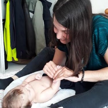 femme massant son bébé avec tendresse
