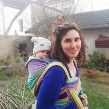 femme portant son bébé en écharpe sur le dos